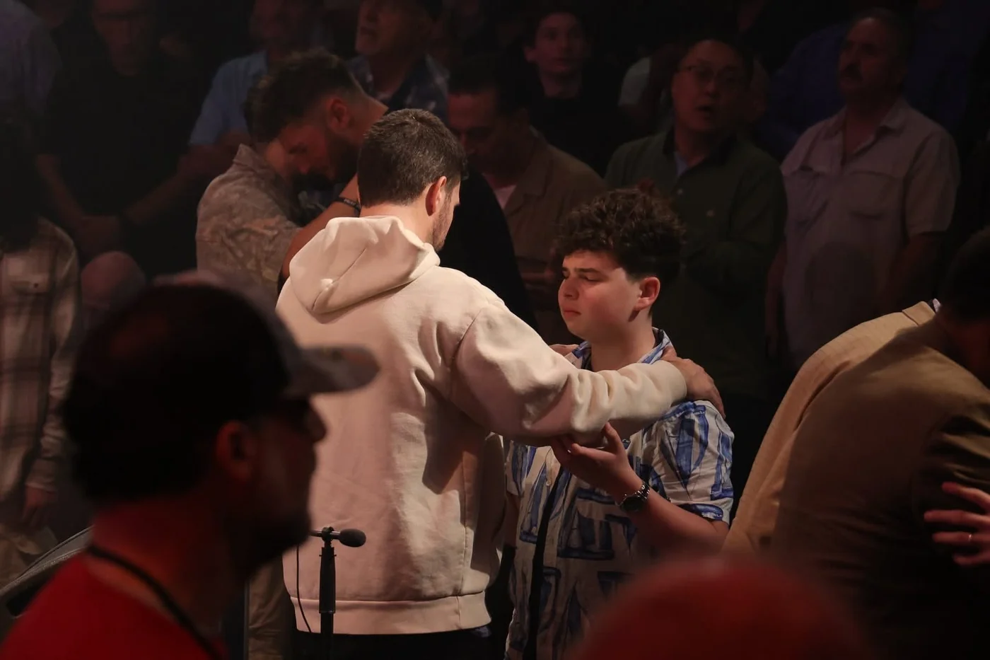 Young men sharing a moment of prayer at Invincible 2026